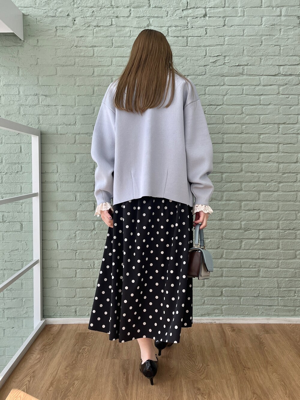 ホワイト系のシャツ/ブラウス、ブルー系のカーディガン/ボレロ、ブラック系のスカートを着用したレディースの冬コーディネートの3枚目の写真