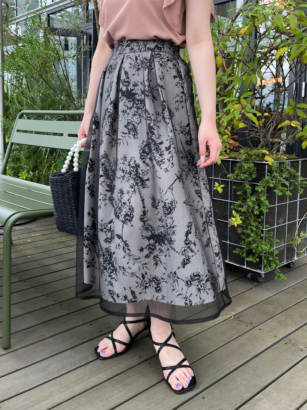 ブラック系のハンドバッグ、ブラック系のサンダル、ピンク系のニット/セーターを着用したレディースの夏コーディネートの5枚目の写真