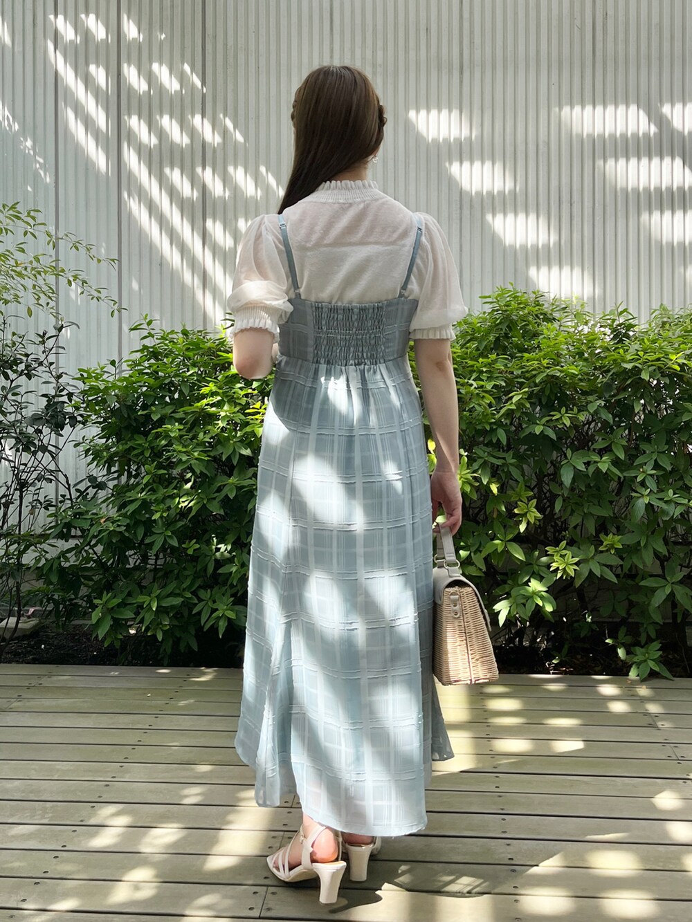 グリーン系のワンピース、ホワイト系のニット/セーター、グレー系のショルダーバッグを着用したレディースの夏コーディネートの3枚目の写真