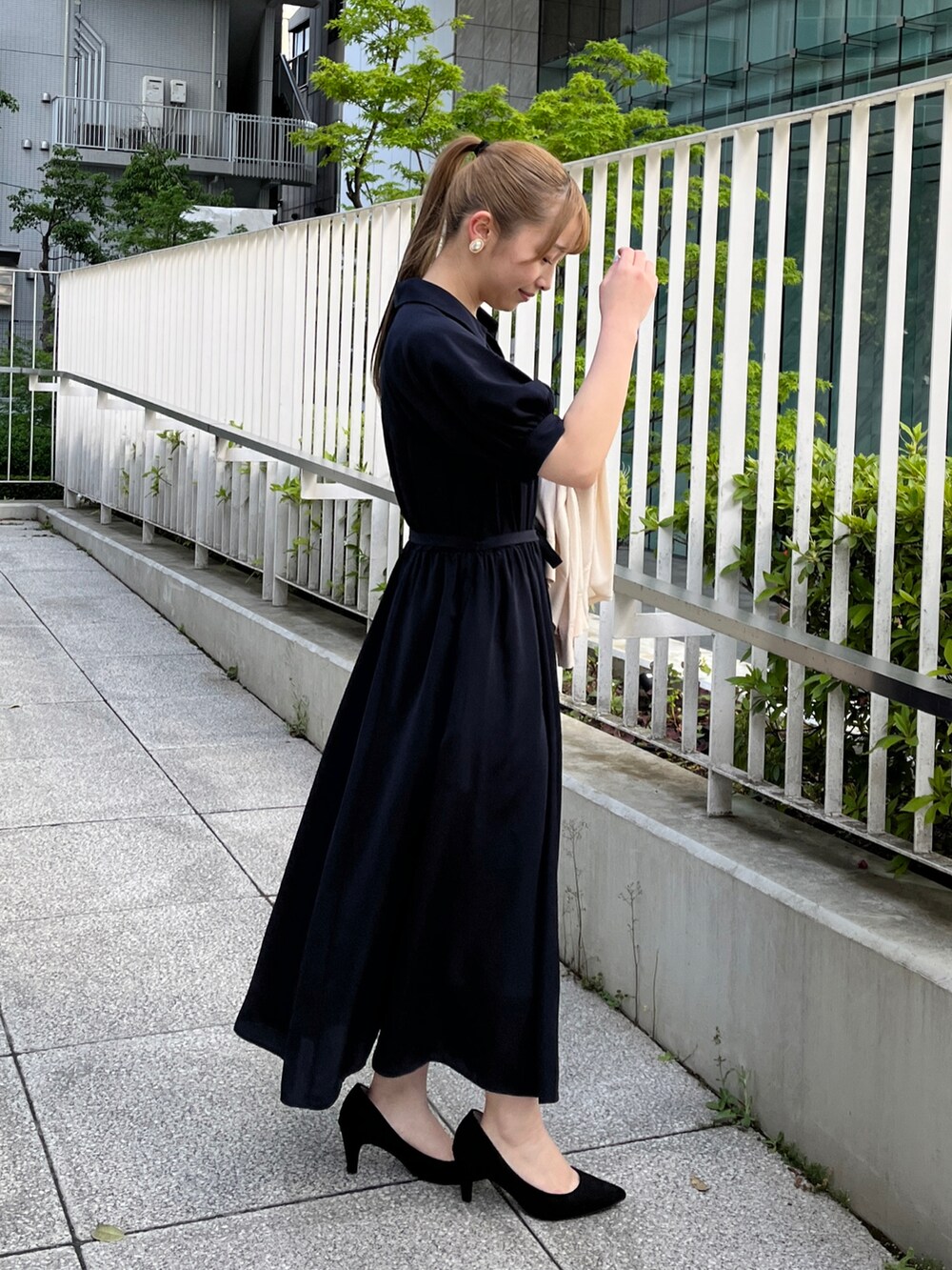 ホワイト系のカーディガン/ボレロ、ブルー系のワンピース、ブラック系のパンプスを着用したレディースの春コーディネートの2枚目の写真