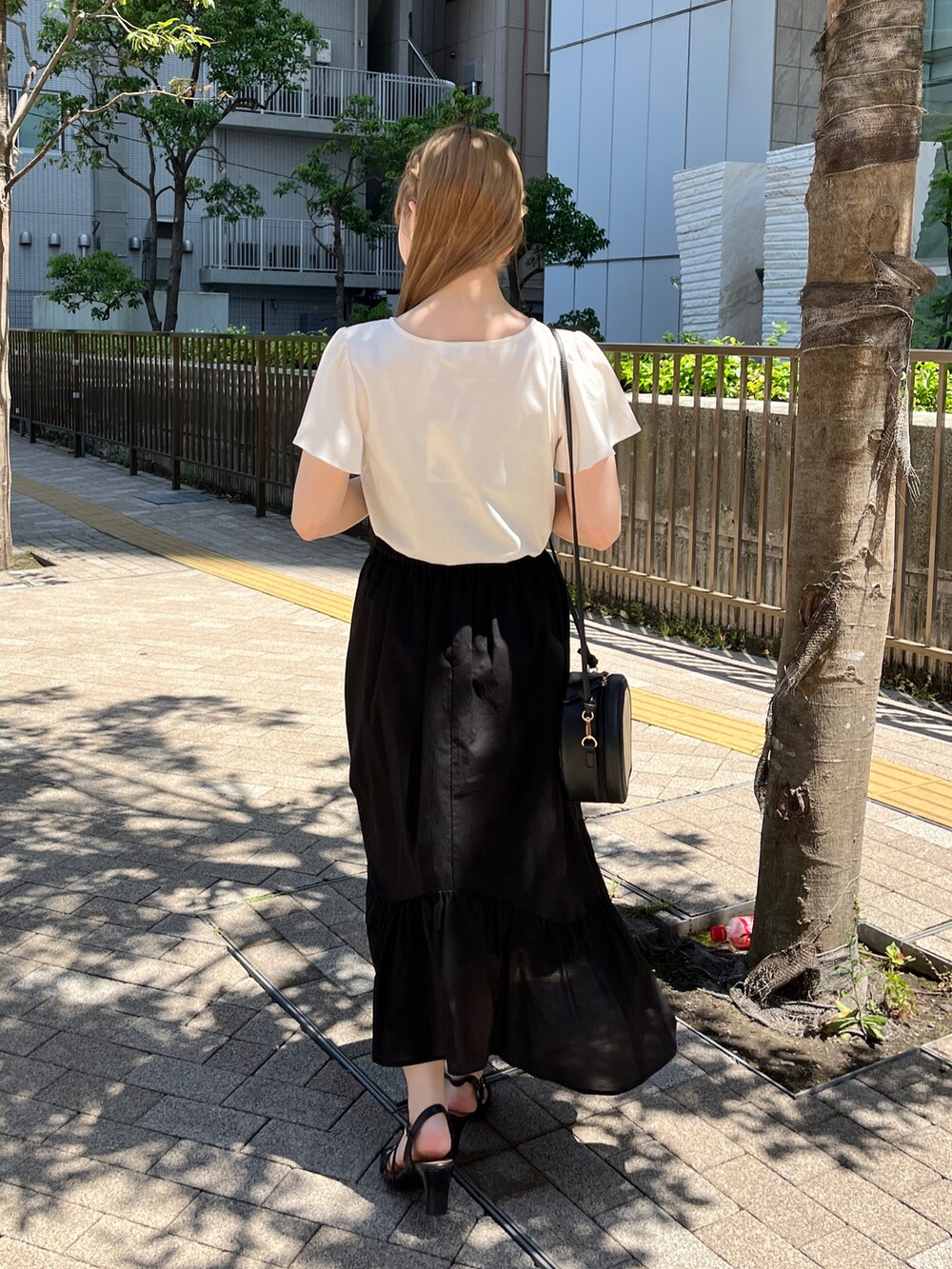 ホワイト系のTシャツ/カットソー、ブラック系のショルダーバッグ、ブラック系のスカートを着用したレディースの春コーディネートの3枚目の写真