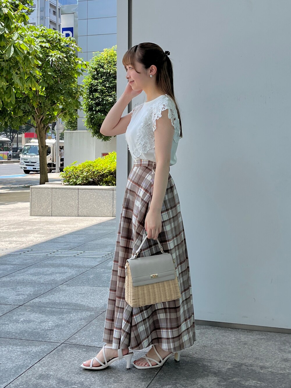 ブラウン系のスカート、ホワイト系のサンダル、グレー系のショルダーバッグを着用したレディースの夏コーディネートの2枚目の写真