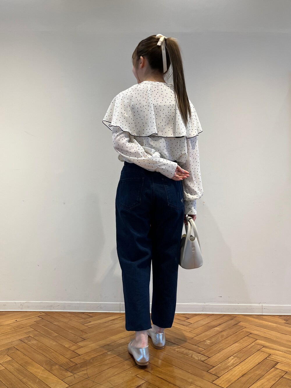 ホワイト系のシャツ/ブラウス、ブルー系のデニムパンツ、ホワイト系のショルダーバッグを着用したレディースの春コーディネートの3枚目の写真