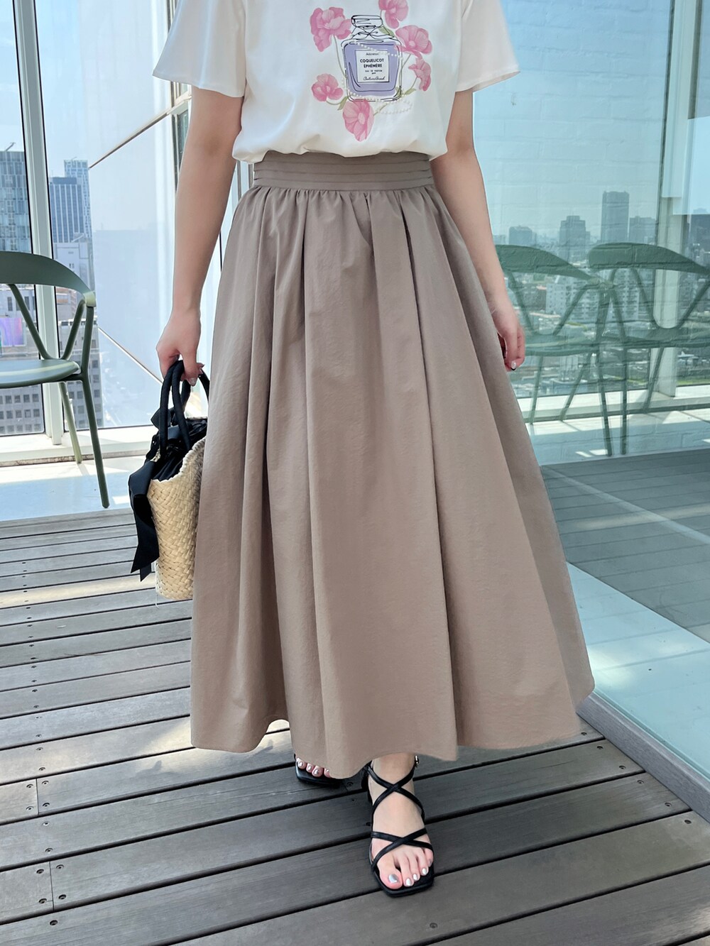 ホワイト系のTシャツ/カットソー、ベージュ系のスカート、ブラック系のハンドバッグを着用したレディースの夏コーディネートの5枚目の写真