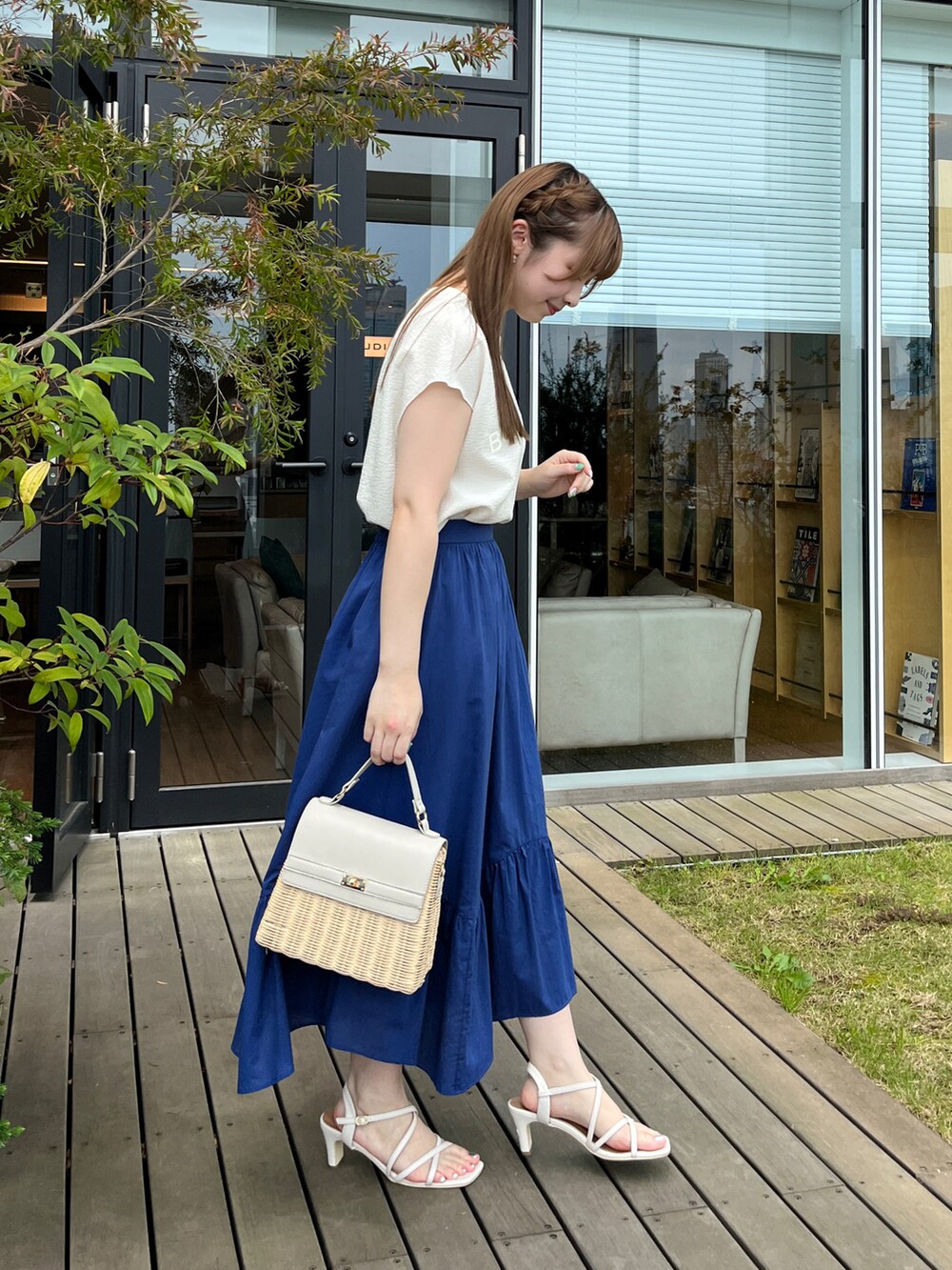 ホワイト系のTシャツ/カットソー、ブルー系のスカート、グレー系のショルダーバッグを着用したレディースの夏コーディネートの2枚目の写真