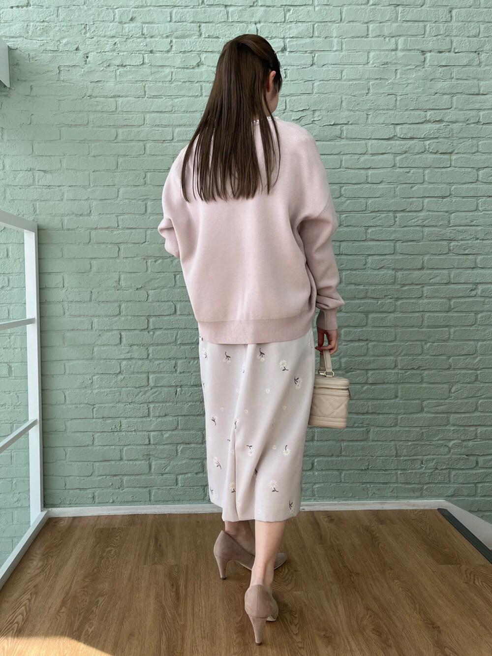 ベージュ系のパンプス、ピンク系のカーディガン/ボレロ、グレー系のワンピースを着用したレディースの冬コーディネートの2枚目の写真