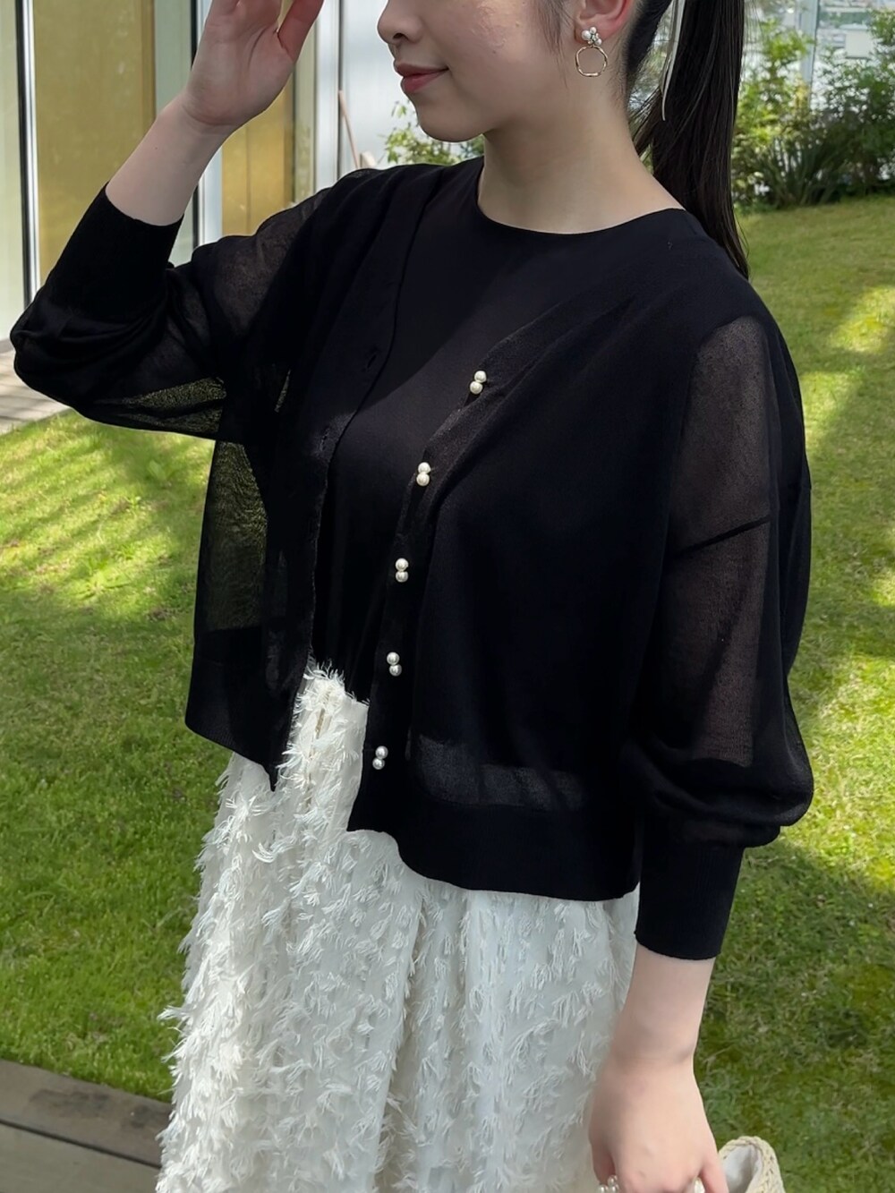 ブラック系のカーディガン/ボレロ、ホワイト系のワンピースを着用したレディースの夏コーディネートの2枚目の写真