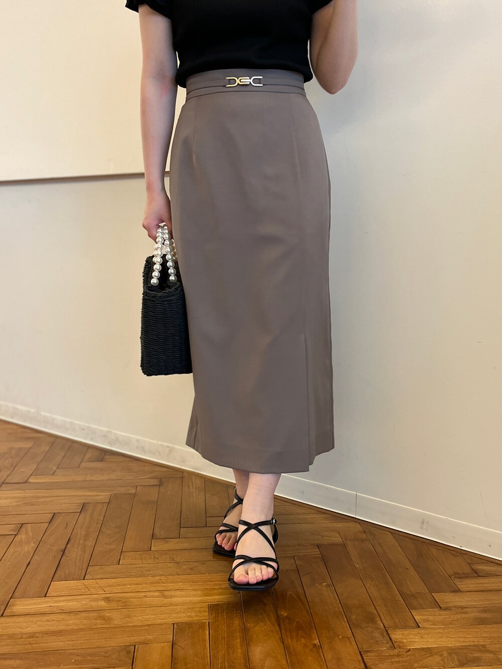 ブラック系のTシャツ/カットソー、ブラウン系のスカート、ブラック系のハンドバッグを着用したレディースの春コーディネートの5枚目の写真