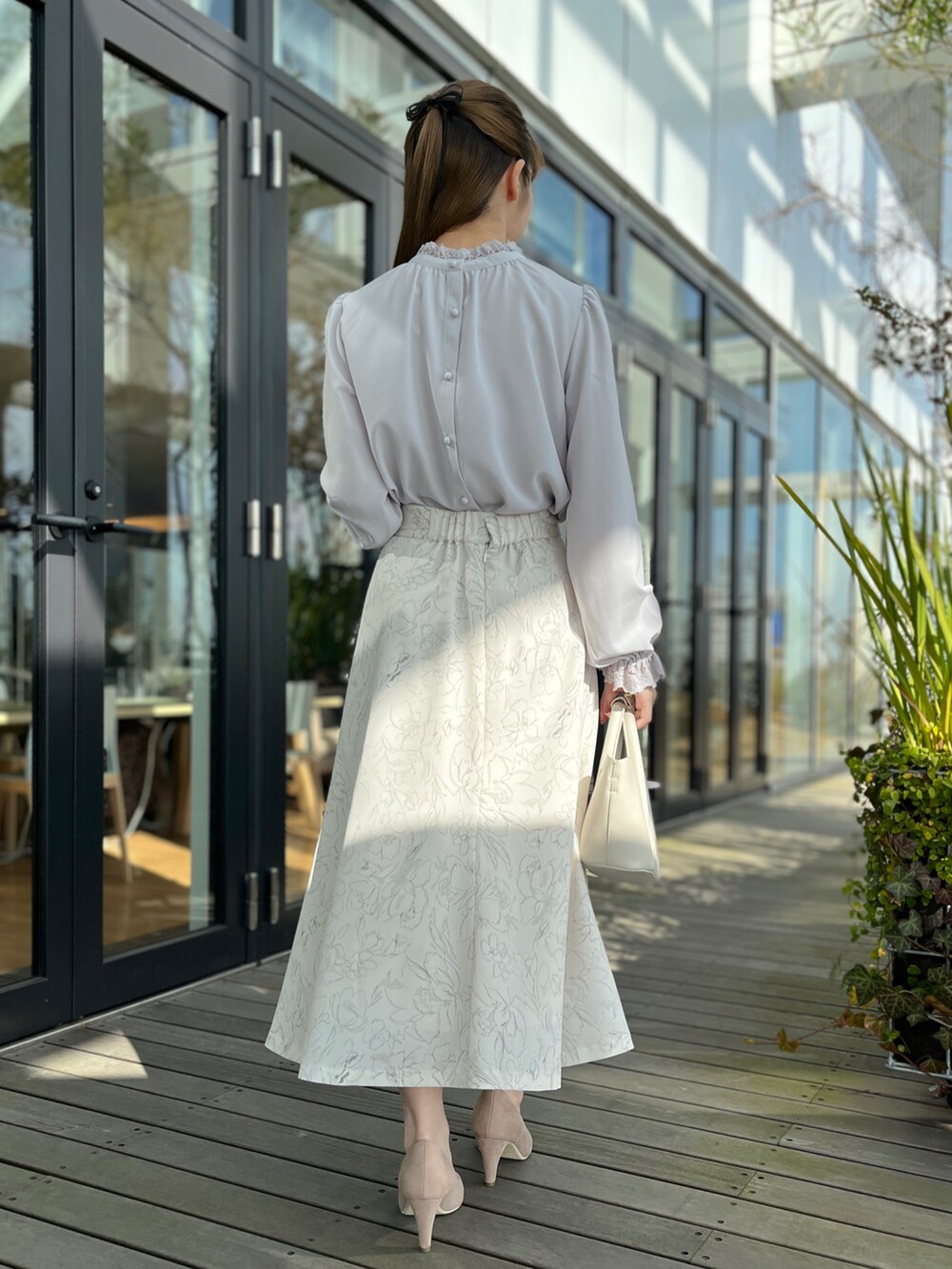 グレー系のシャツ/ブラウス、ベージュ系のスカート、ベージュ系のパンプスを着用したレディースの冬コーディネートの3枚目の写真