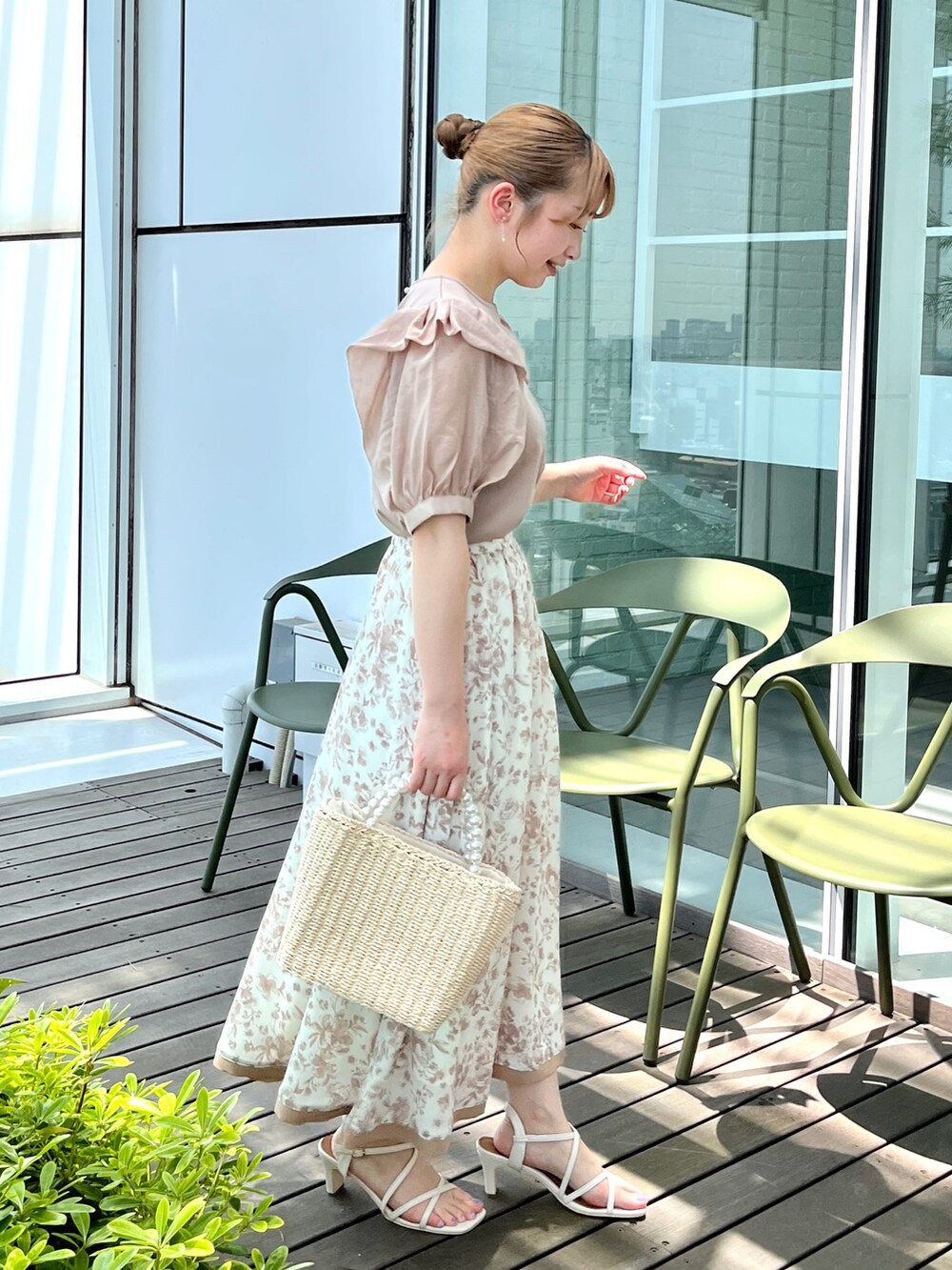 ベージュ系のTシャツ/カットソー、ベージュ系のスカート、ベージュ系のハンドバッグを着用したレディースの夏コーディネートの2枚目の写真