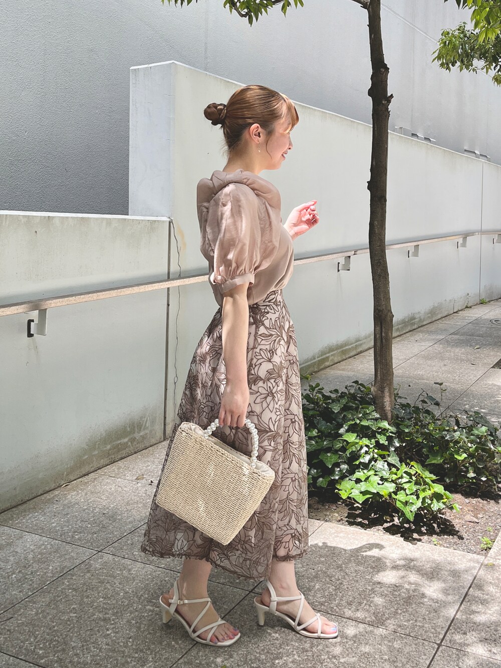 ベージュ系のTシャツ/カットソー、ブラウン系のスカート、ベージュ系のハンドバッグを着用したレディースの夏コーディネートの2枚目の写真