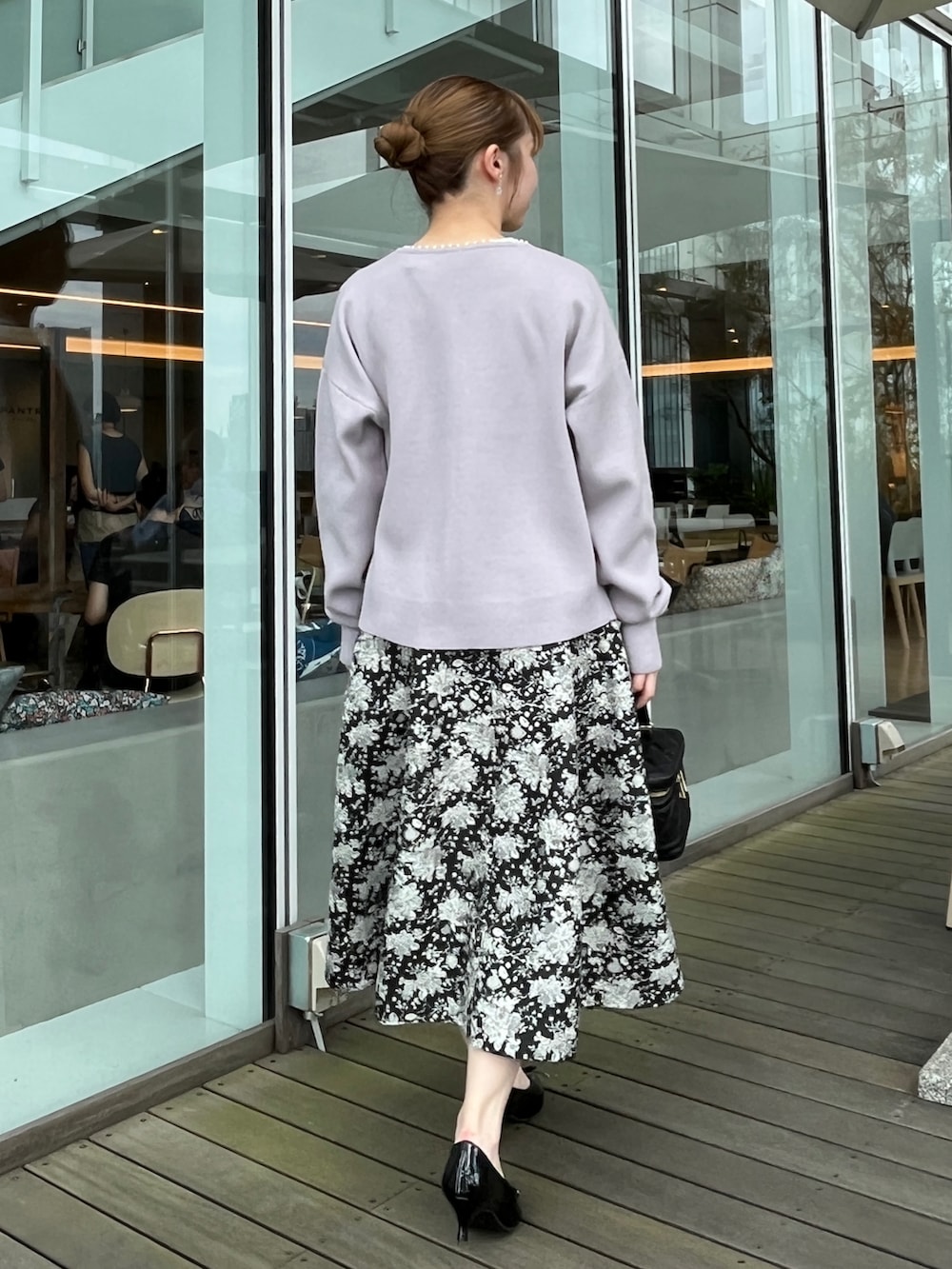 ホワイト系のTシャツ/カットソー、ブラック系のスカート、ブルー系のカーディガン/ボレロを着用したレディースの秋コーディネートの3枚目の写真