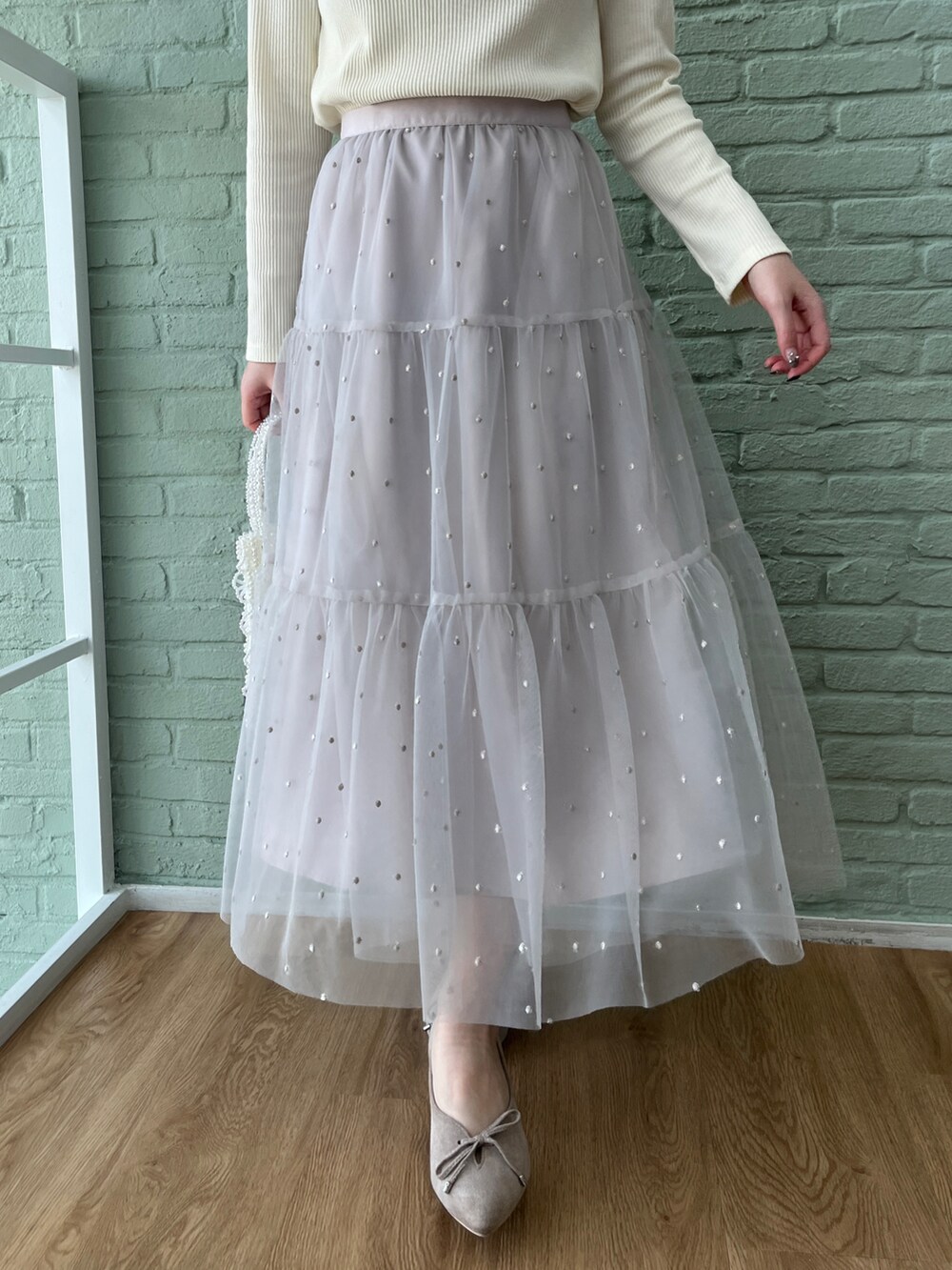 ホワイト系のTシャツ/カットソー、グレー系のスカートを着用したレディースの冬コーディネートの5枚目の写真