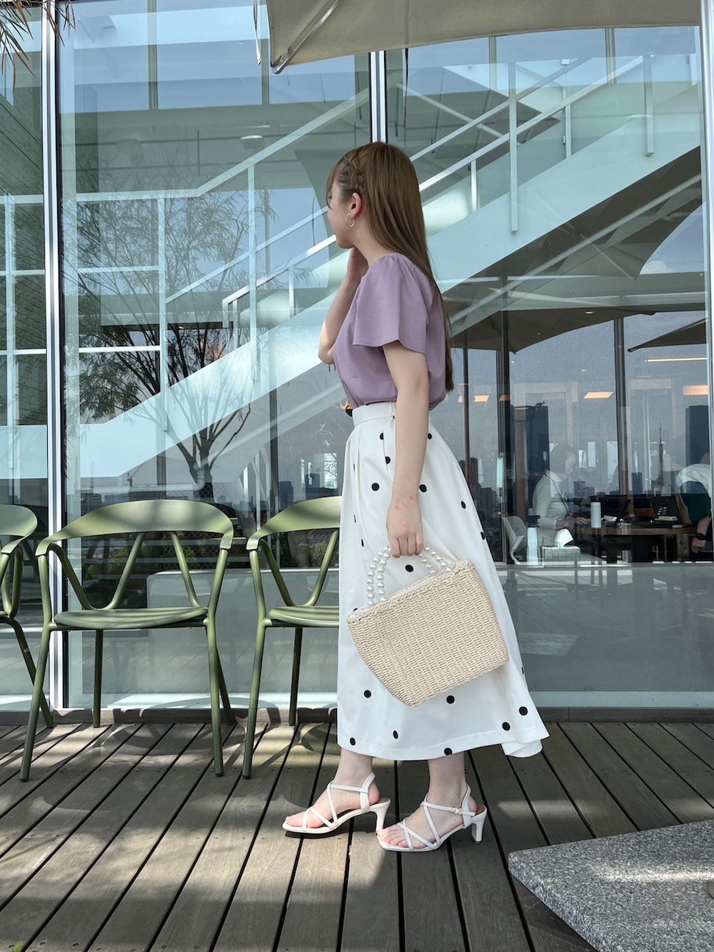 パープル系のTシャツ/カットソー、ベージュ系のハンドバッグ、ホワイト系のサンダルを着用したレディースの春コーディネートの2枚目の写真