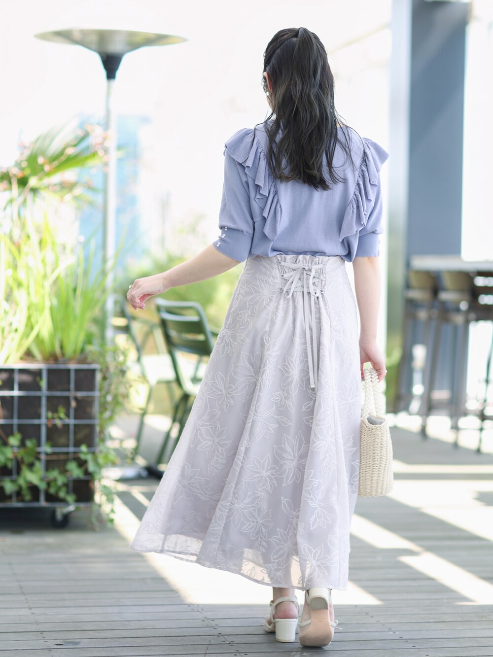 ブルー系のニット/セーター、グレー系のスカートを着用したレディースの春コーディネートの3枚目の写真