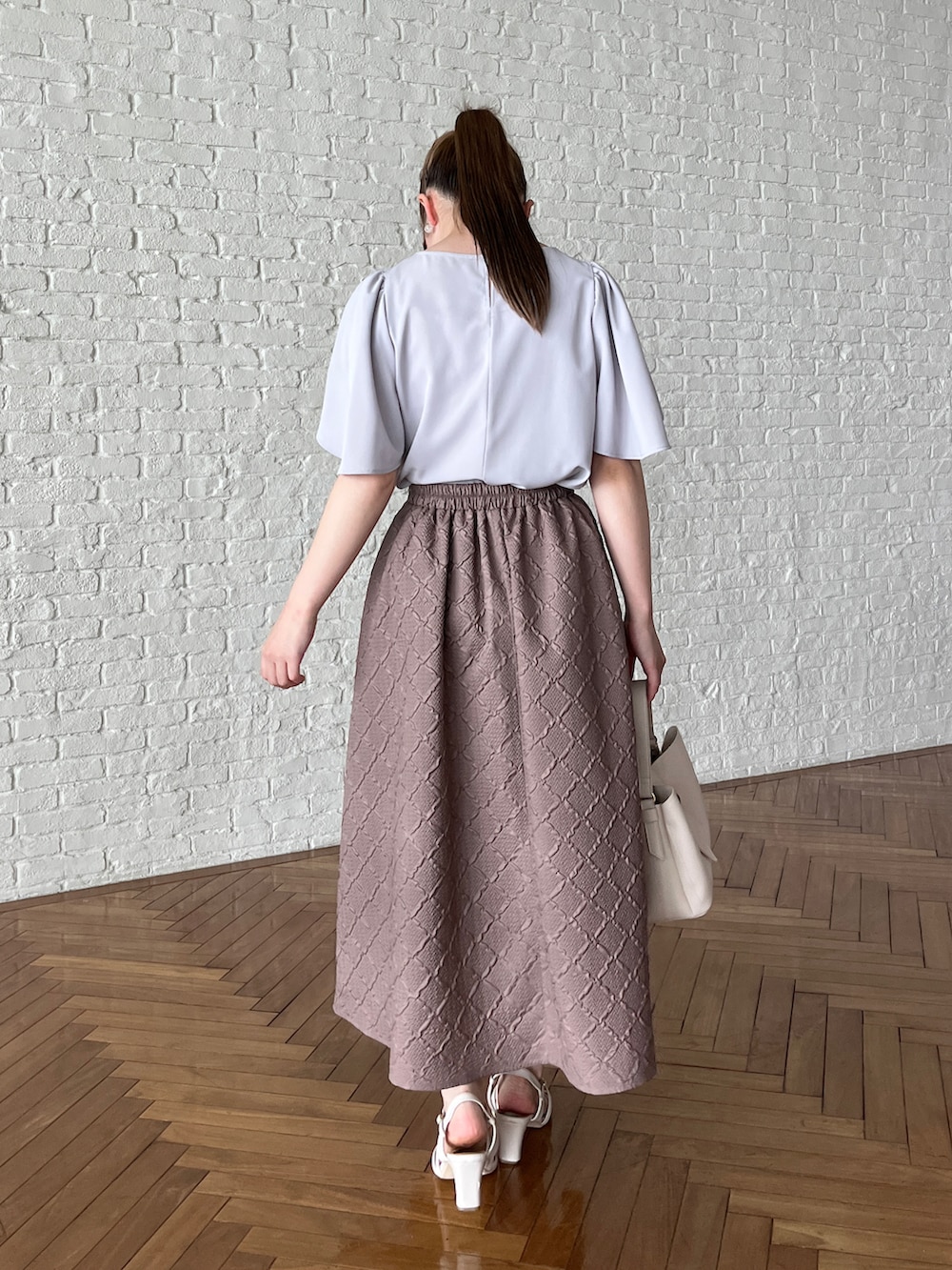 グレー系のシャツ/ブラウス、ブラウン系のスカート、ホワイト系のショルダーバッグを着用したレディースの夏コーディネートの3枚目の写真