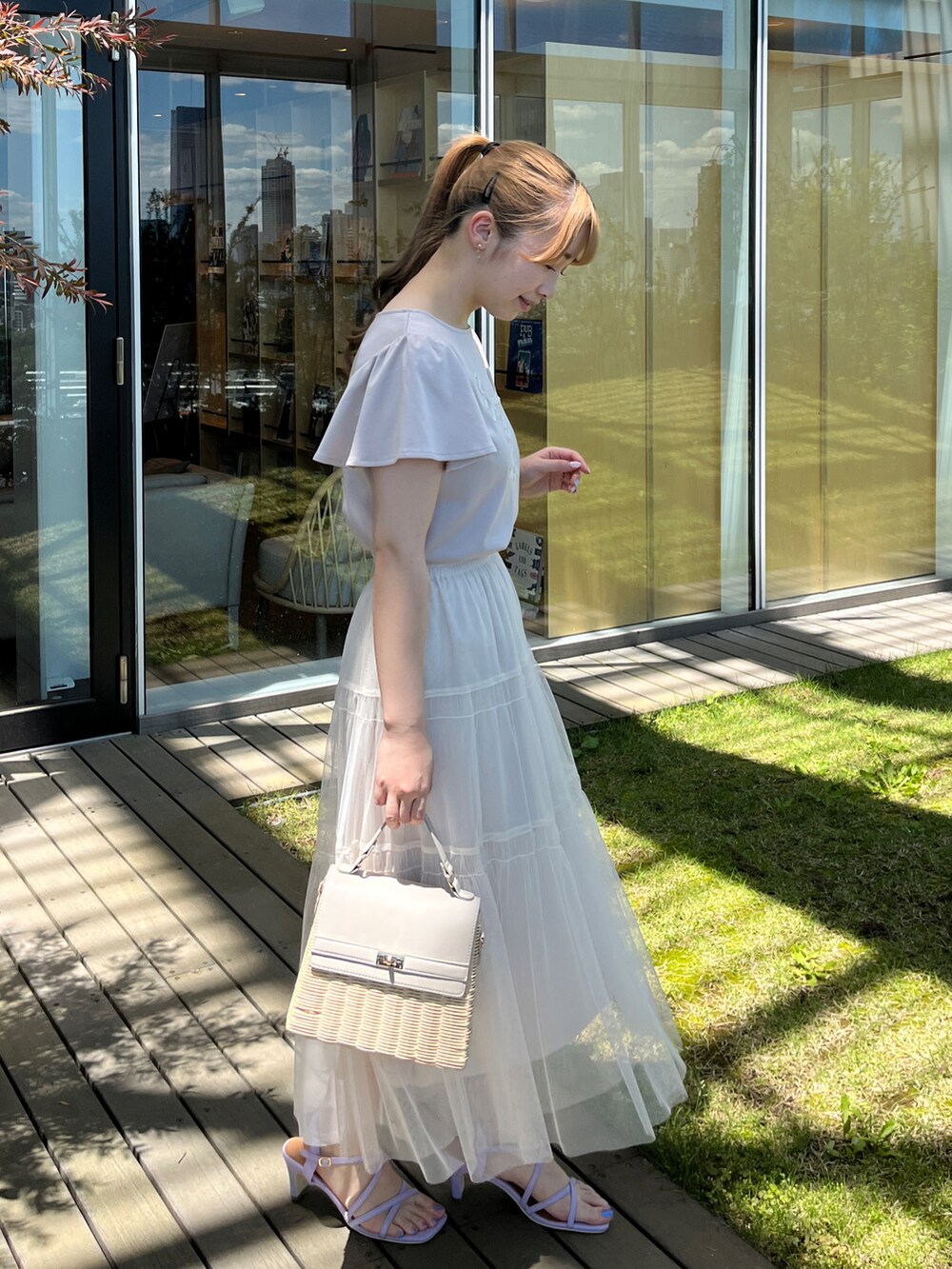 グレー系のTシャツ/カットソー、ホワイト系のスカート、グレー系のショルダーバッグを着用したレディースの夏コーディネートの2枚目の写真