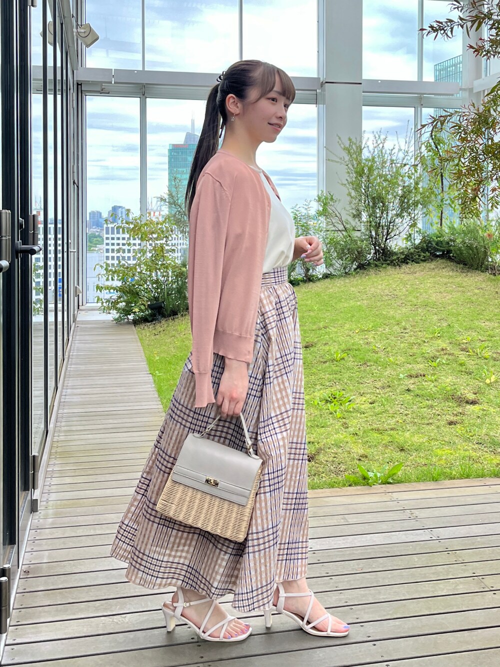 ホワイト系のニット/セーター、グレー系のショルダーバッグ、ホワイト系のサンダルを着用したレディースの夏コーディネートの2枚目の写真