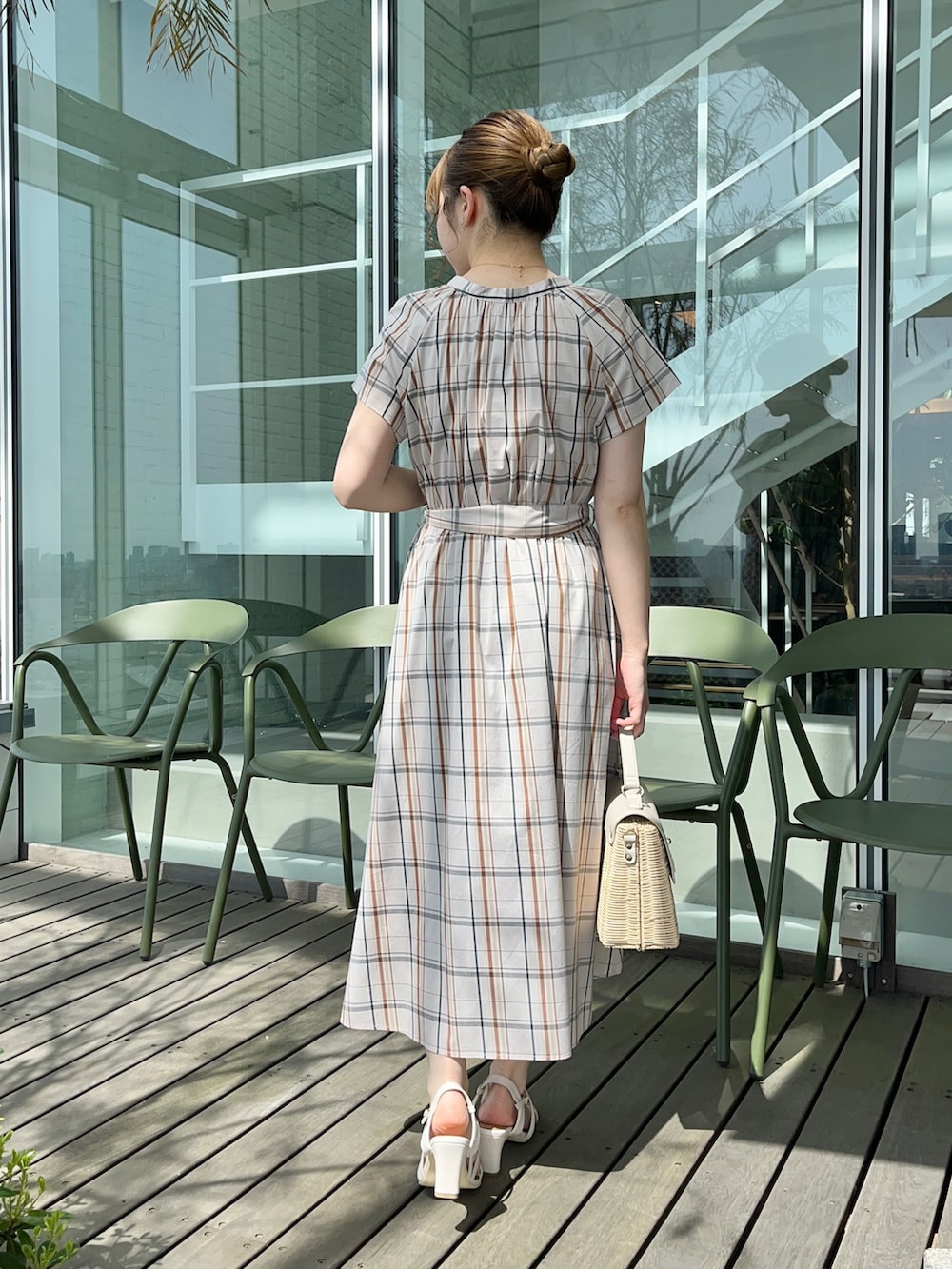 ベージュ系のワンピース、グレー系のショルダーバッグ、ホワイト系のサンダルを着用したレディースの春コーディネートの3枚目の写真