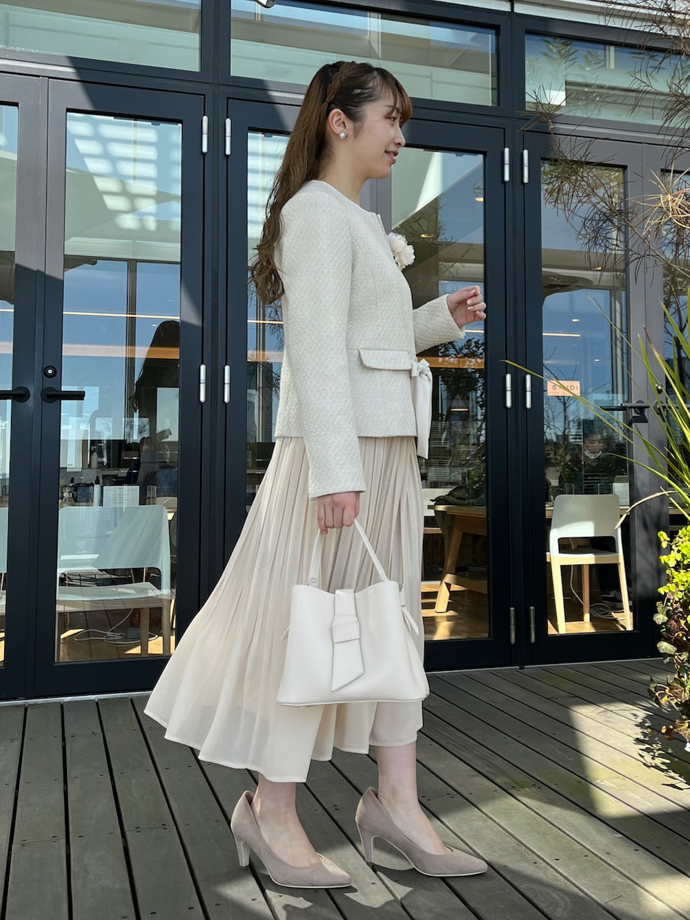 ベージュ系のノーカラージャケット、ホワイト系のスカート、ベージュ系のパンプスを着用したレディースの冬コーディネートの2枚目の写真