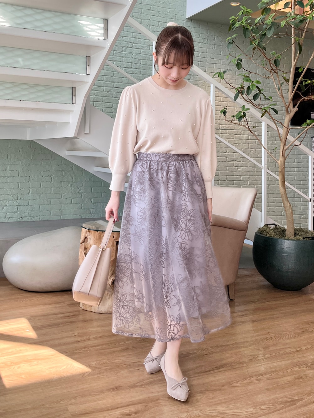 ホワイト系のニット/セーター、ベージュ系のその他アウター、グレー系のスカートを着用したレディースの冬コーディネートの3枚目の写真