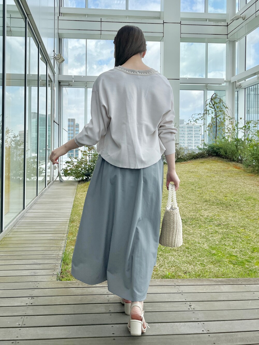 ホワイト系のカーディガン/ボレロ、ブルー系のワンピースを着用したレディースの春コーディネートの2枚目の写真