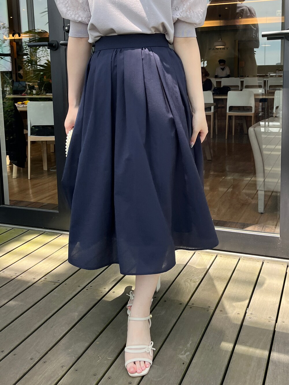 グレー系のニット/セーター、ブルー系のスカートを着用したレディースの春コーディネートの5枚目の写真