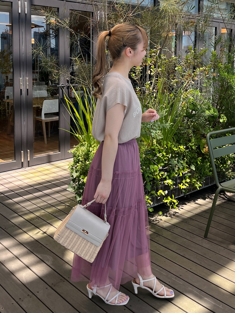 ベージュ系のTシャツ/カットソー、パープル系のスカート、グレー系のショルダーバッグを着用したレディースの夏コーディネートの2枚目の写真