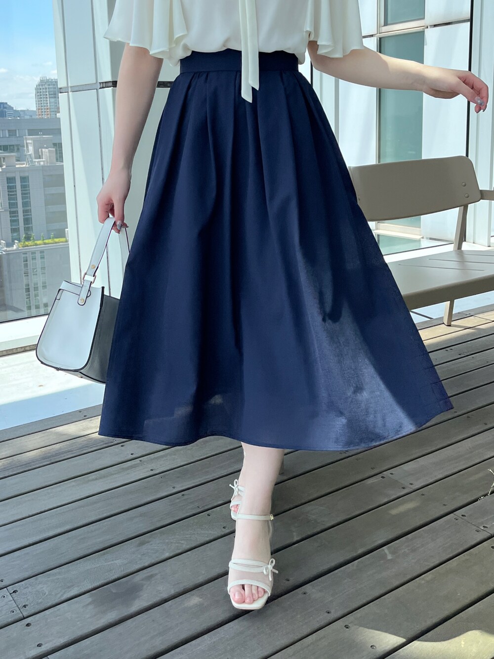 ホワイト系のシャツ/ブラウス、ブルー系のスカートを着用したレディースの春コーディネートの4枚目の写真