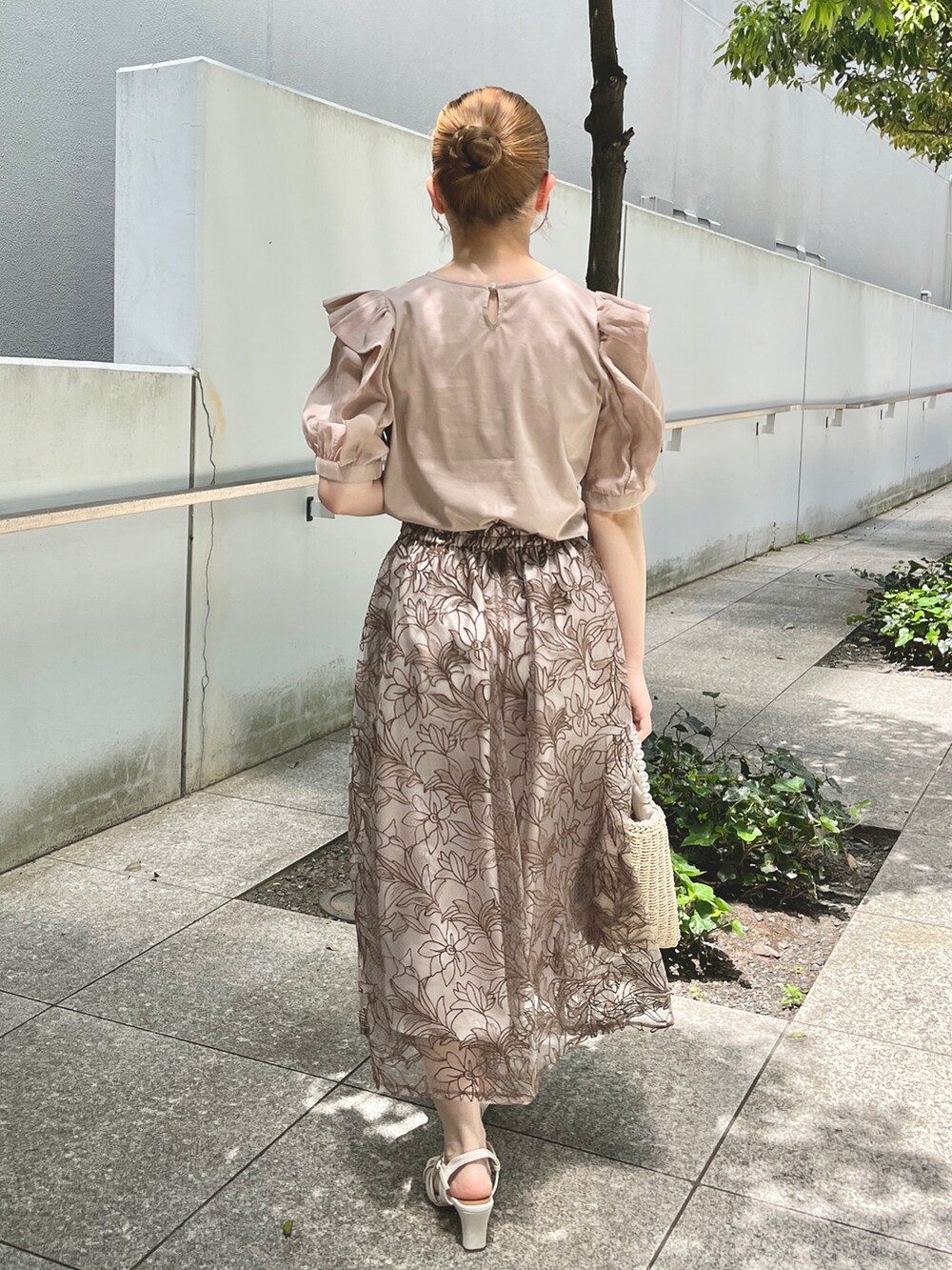 ベージュ系のTシャツ/カットソー、ブラウン系のスカート、ベージュ系のハンドバッグを着用したレディースの夏コーディネートの3枚目の写真