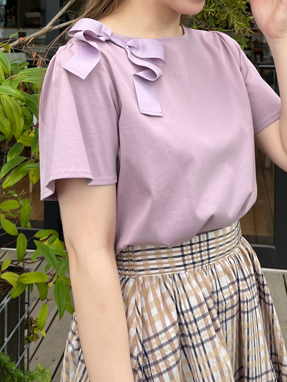 パープル系のTシャツ/カットソー、ベージュ系のスカート、ベージュ系のハンドバッグを着用したレディースの夏コーディネートの4枚目の写真