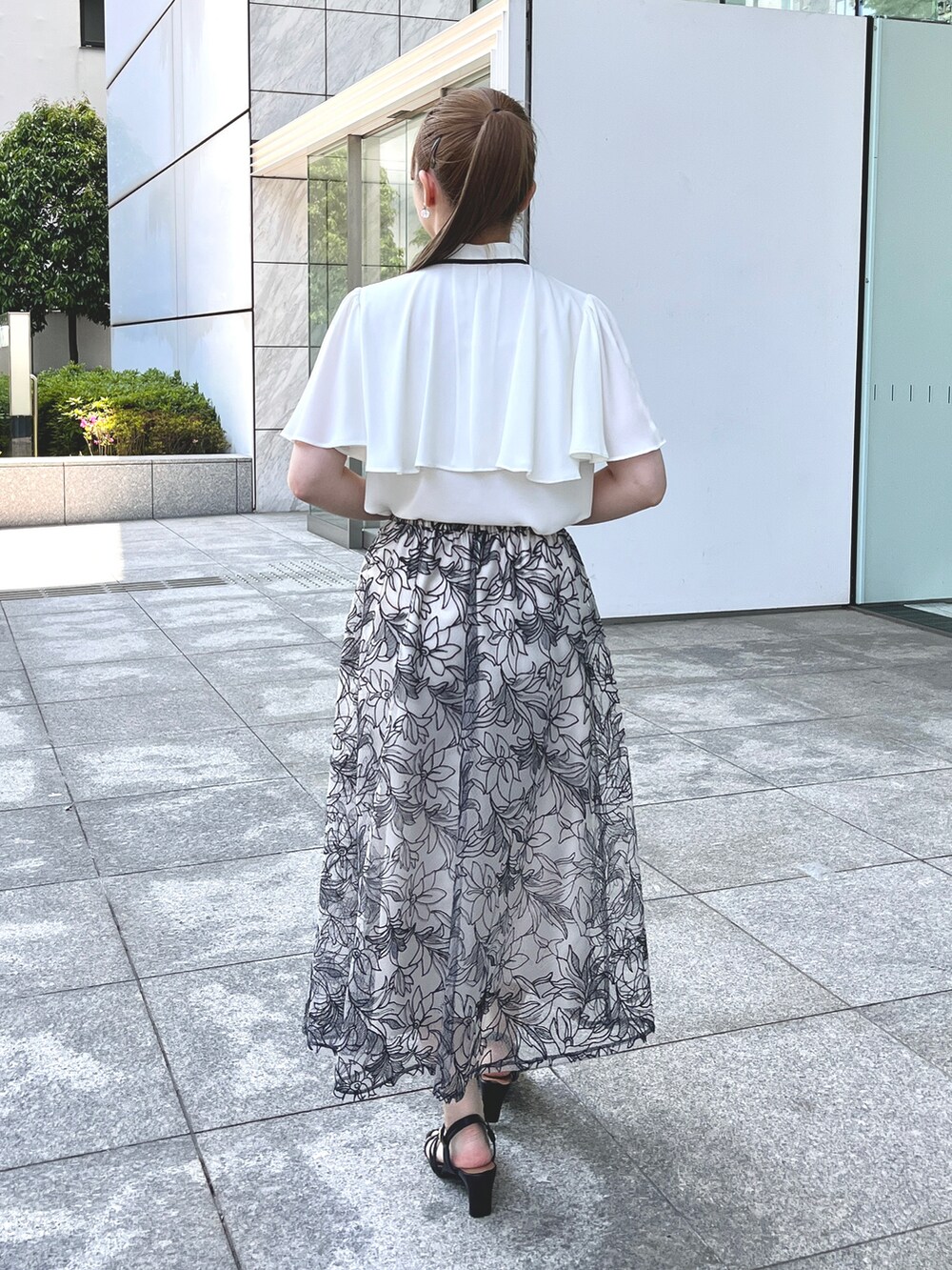 ホワイト系のシャツ/ブラウス、ブラック系のスカート、ブラック系のハンドバッグを着用したレディースの夏コーディネートの3枚目の写真