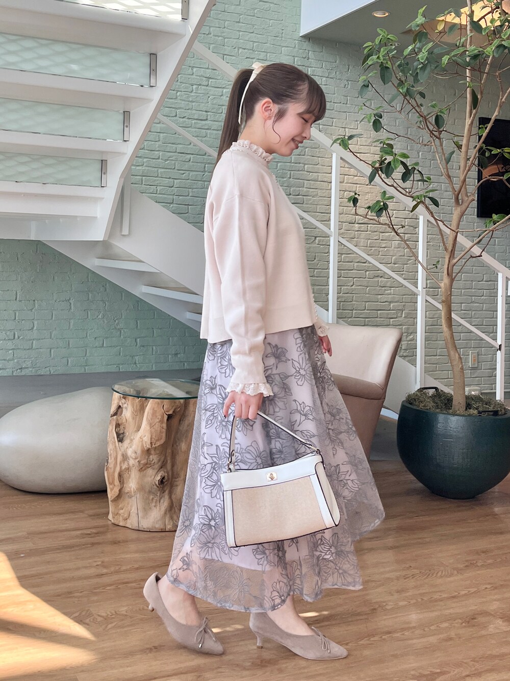 ホワイト系のカーディガン/ボレロ、ホワイト系のシャツ/ブラウス、グレー系のスカートを着用したレディースの冬コーディネートの2枚目の写真