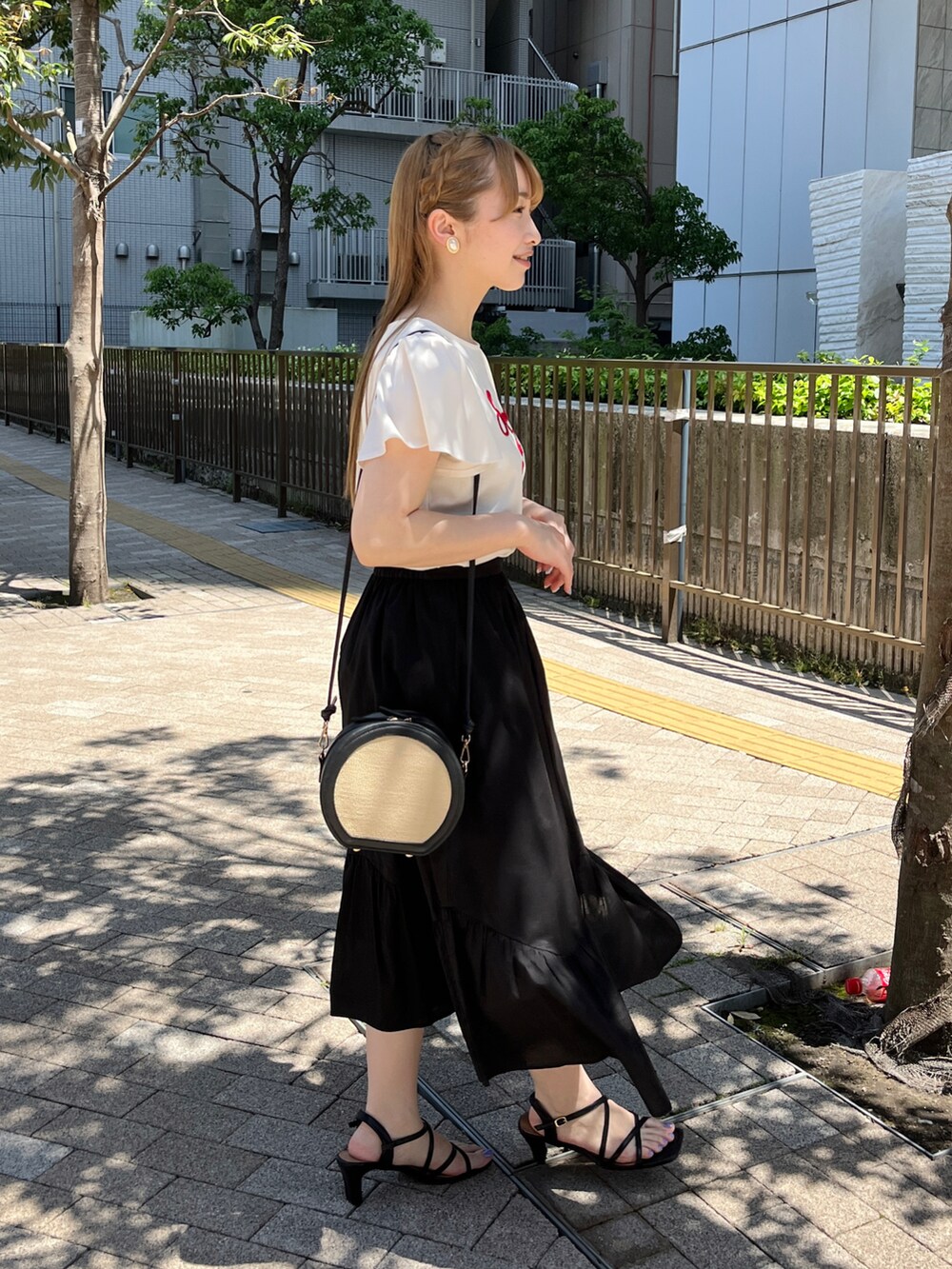 ホワイト系のTシャツ/カットソー、ブラック系のショルダーバッグ、ブラック系のスカートを着用したレディースの春コーディネートの2枚目の写真