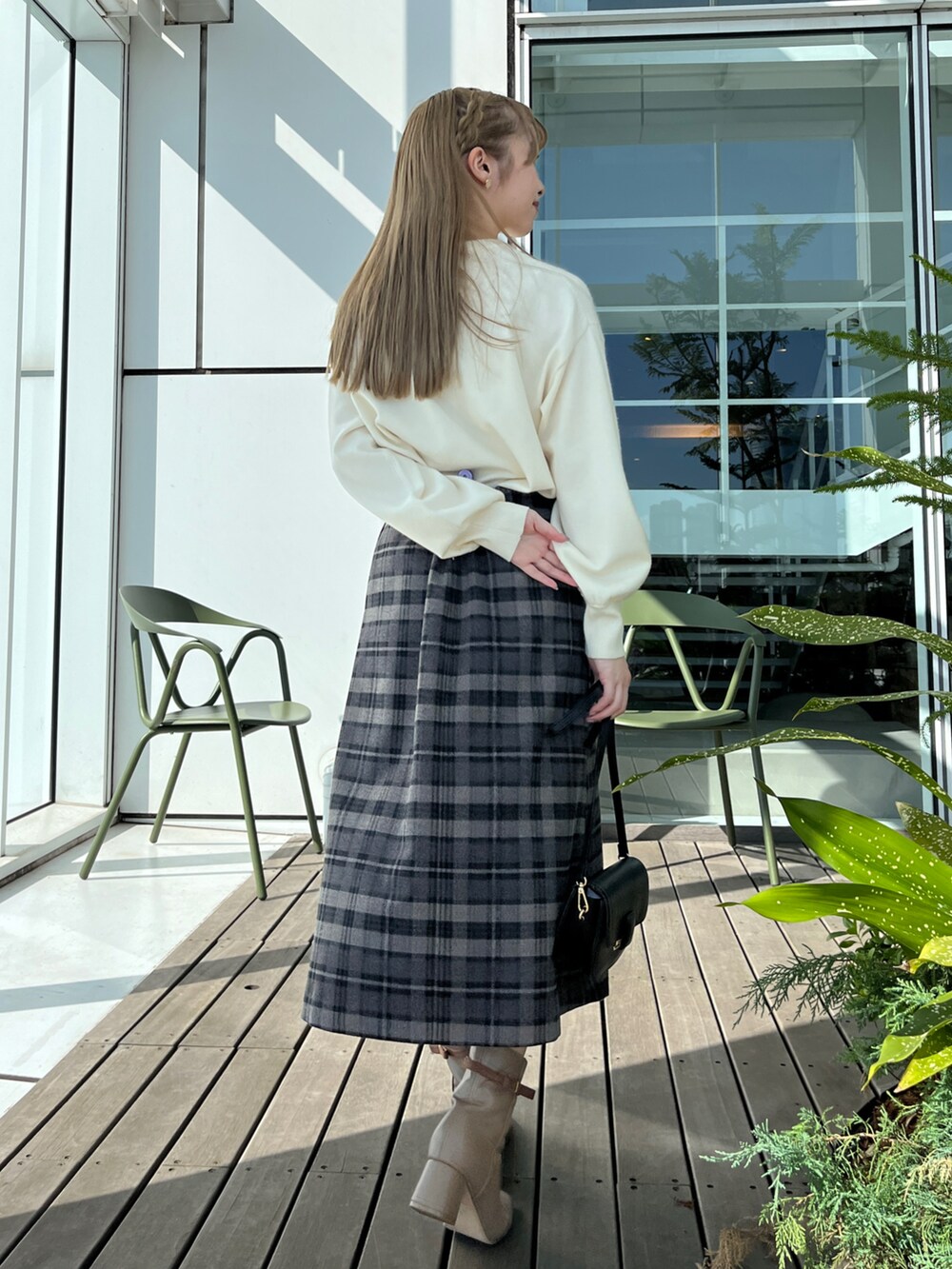 ブラック系のダウンジャケット/コート、ホワイト系のニット/セーター、グレー系のスカートを着用したレディースの秋コーディネートの5枚目の写真