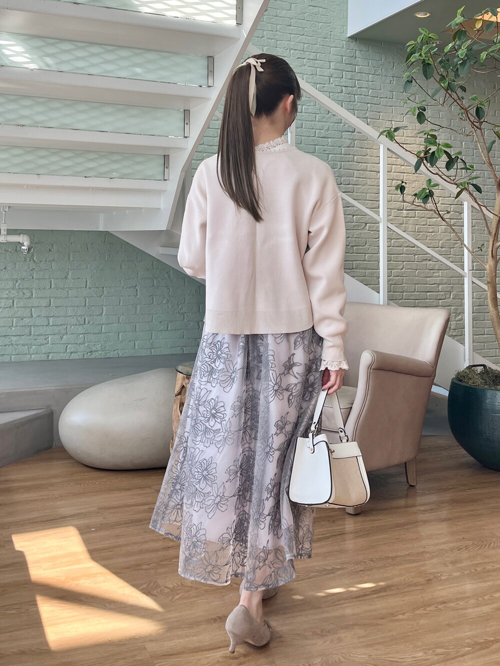 ホワイト系のカーディガン/ボレロ、ホワイト系のシャツ/ブラウス、グレー系のスカートを着用したレディースの冬コーディネートの3枚目の写真