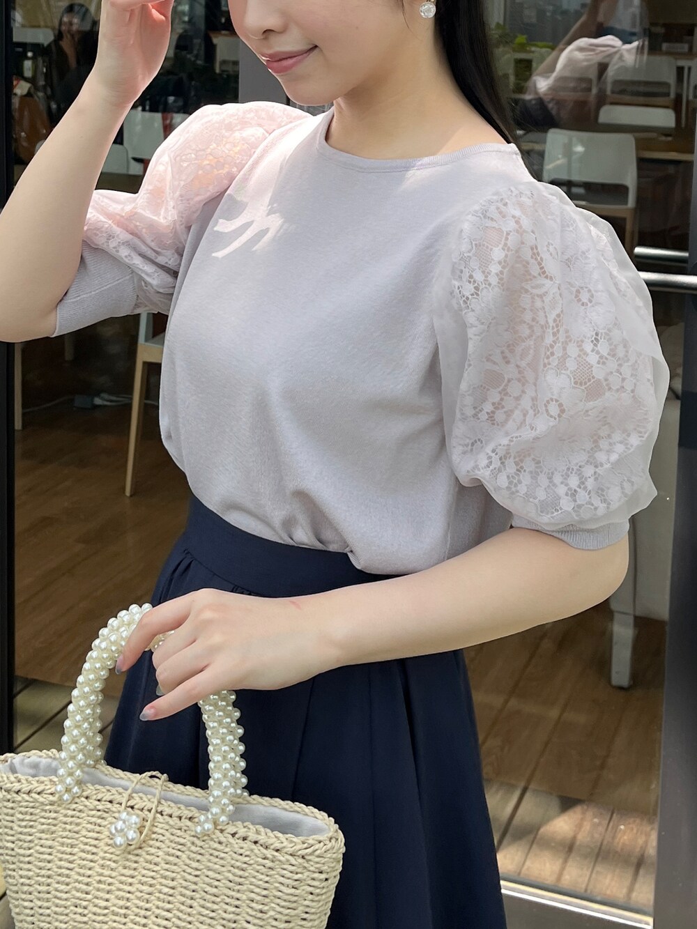 グレー系のニット/セーター、ブルー系のスカートを着用したレディースの春コーディネートの3枚目の写真