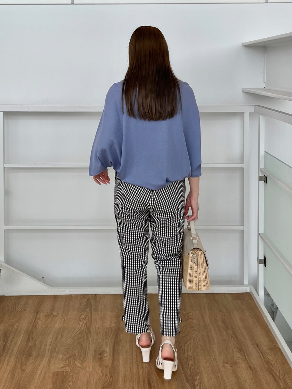 ブルー系のニット/セーター、ブラック系のその他パンツ、グレー系のショルダーバッグを着用したレディースの夏コーディネートの3枚目の写真