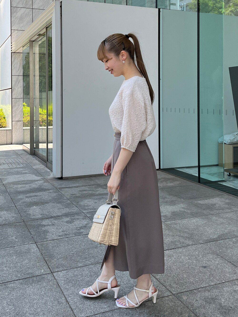 ホワイト系のTシャツ/カットソー、ブラウン系のスカート、グレー系のショルダーバッグを着用したレディースの夏コーディネートの2枚目の写真