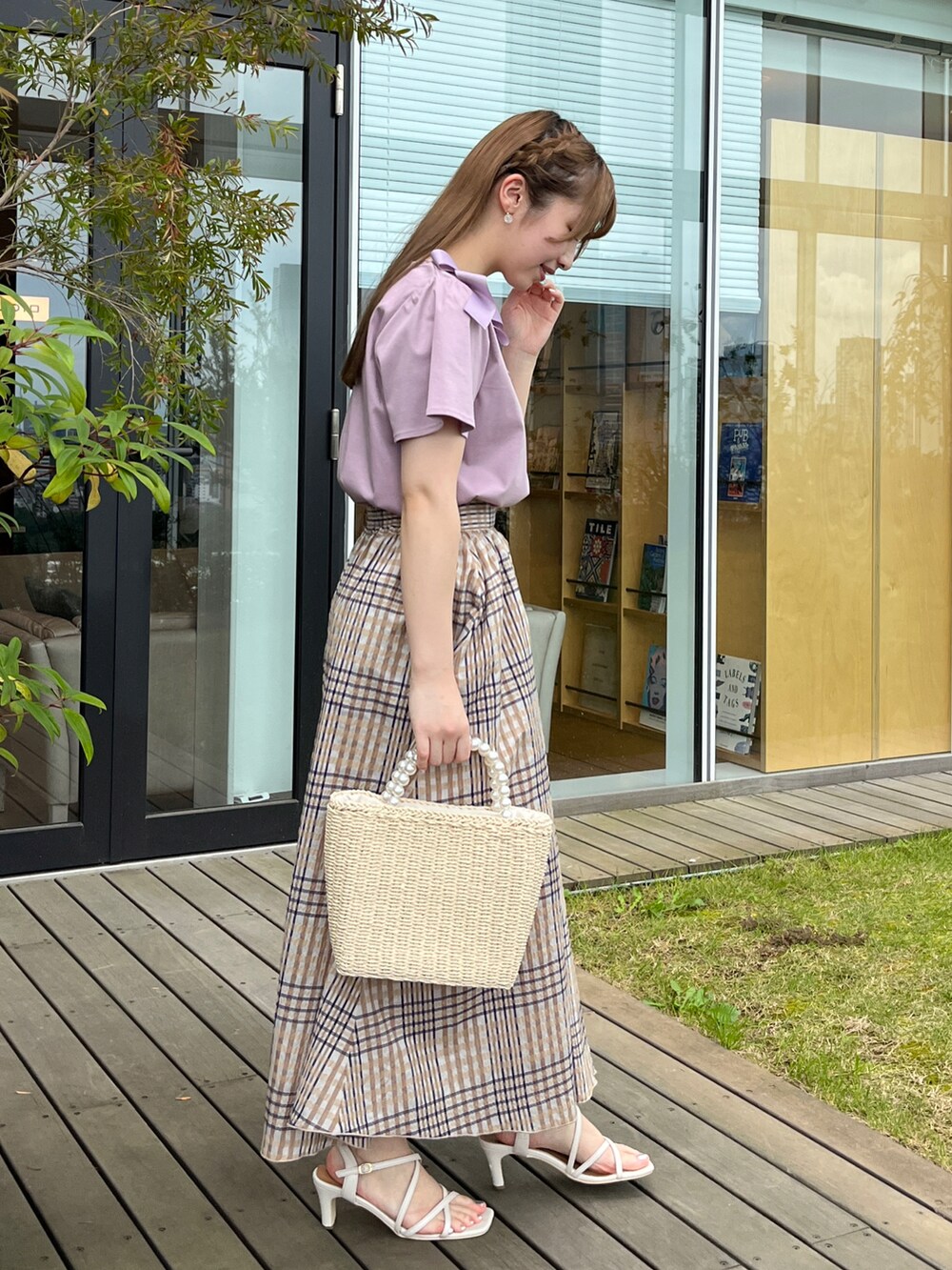 パープル系のTシャツ/カットソー、ベージュ系のスカート、ベージュ系のハンドバッグを着用したレディースの夏コーディネートの2枚目の写真