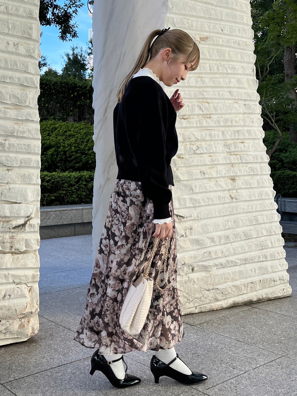 ブラック系のカーディガン/ボレロ、ブラウン系のスカート、ホワイト系のショルダーバッグを着用したレディースの秋コーディネートの2枚目の写真