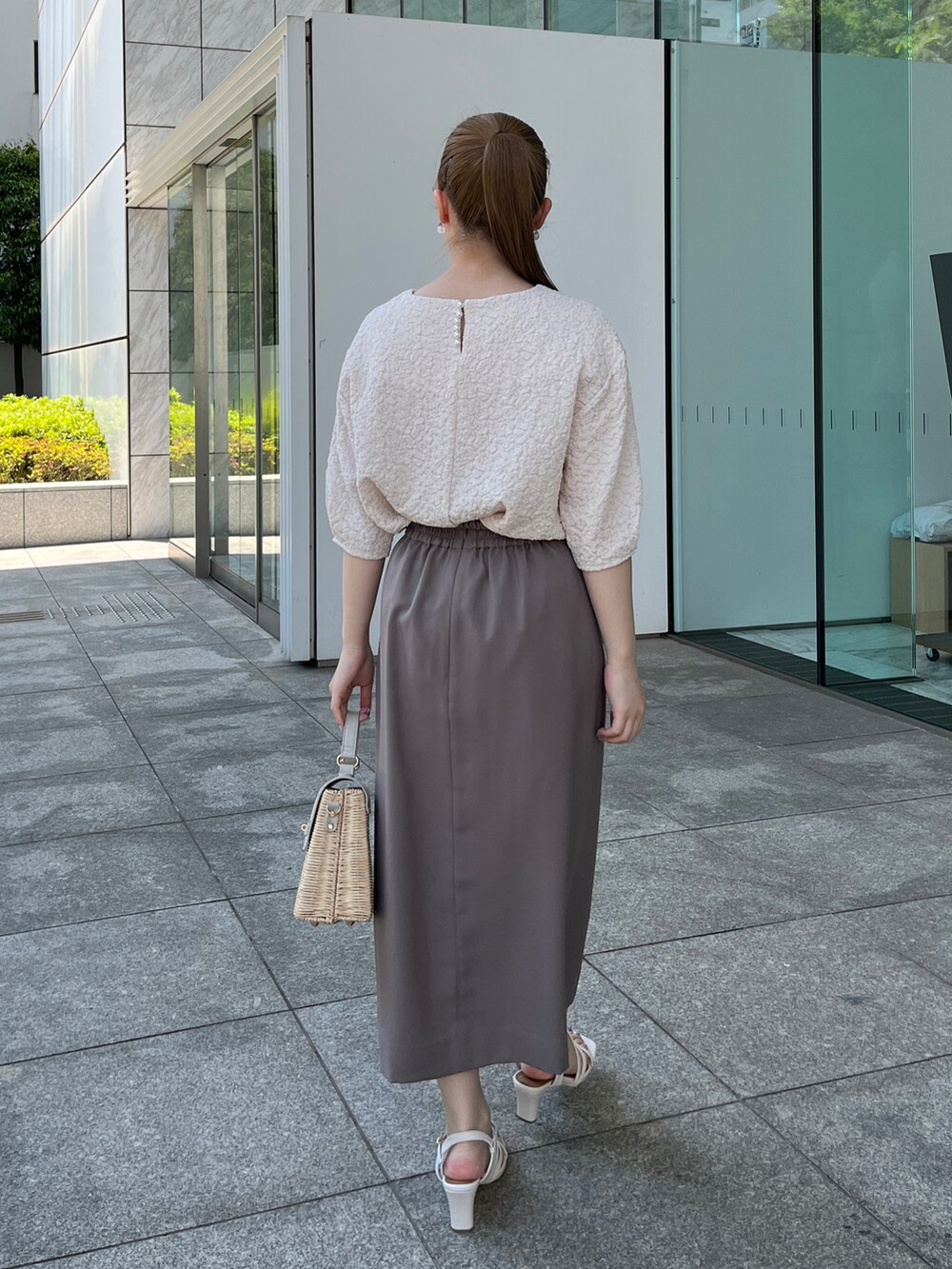 ホワイト系のTシャツ/カットソー、ブラウン系のスカート、グレー系のショルダーバッグを着用したレディースの夏コーディネートの3枚目の写真