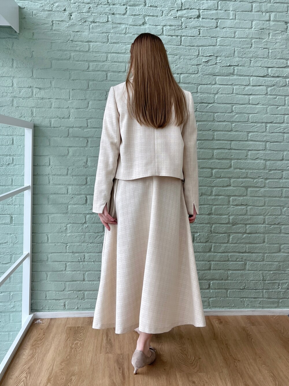 ベージュ系のテーラードジャケット、ベージュ系のワンピースを着用したレディースの春コーディネートの3枚目の写真