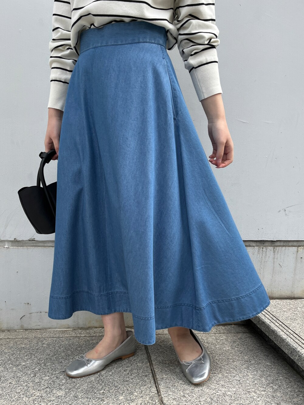 ホワイト系のニット/セーター、ブルー系のスカート、ブラック系のショルダーバッグを着用したレディースの冬コーディネートの5枚目の写真