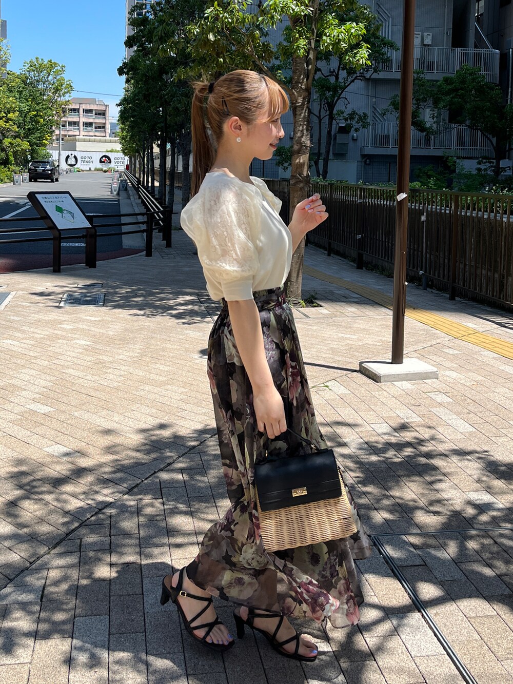 ホワイト系のニット/セーター、ブラック系のスカート、ブラック系のショルダーバッグを着用したレディースの夏コーディネートの2枚目の写真