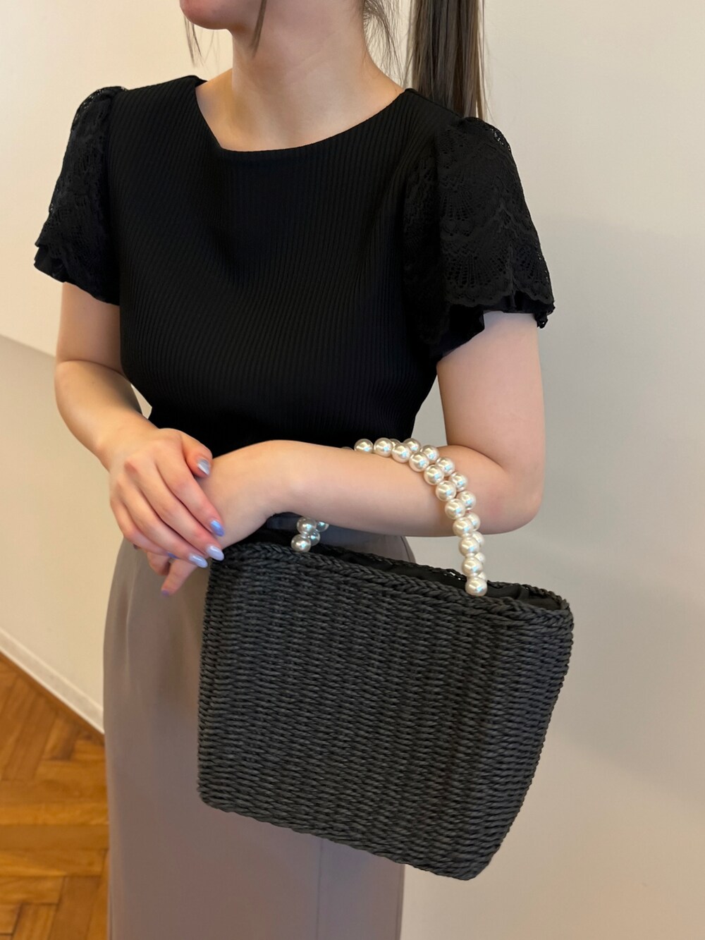 ブラック系のTシャツ/カットソー、ブラウン系のスカート、ブラック系のハンドバッグを着用したレディースの春コーディネートの4枚目の写真