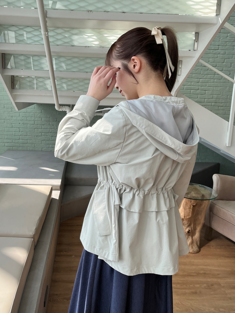 グリーン系のブルゾン、ブルー系のワンピースを着用したレディースの冬コーディネートの4枚目の写真