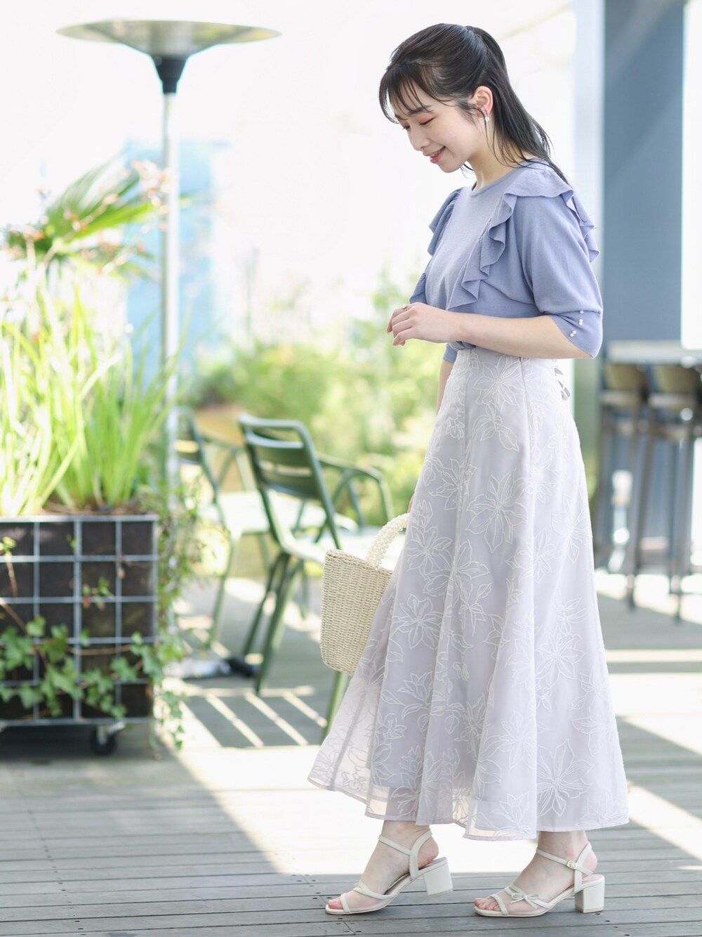 ブルー系のニット/セーター、グレー系のスカートを着用したレディースの春コーディネートの2枚目の写真