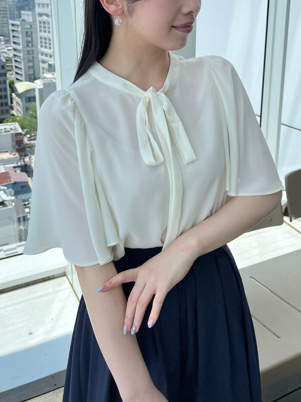 ホワイト系のシャツ/ブラウス、ブルー系のスカートを着用したレディースの春コーディネートの3枚目の写真