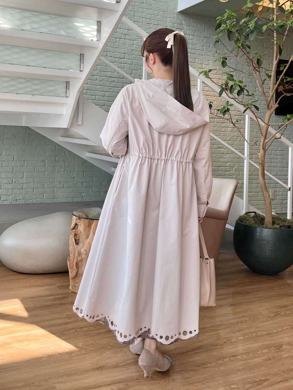 ホワイト系のニット/セーター、ベージュ系のその他アウター、グレー系のスカートを着用したレディースの冬コーディネートの2枚目の写真